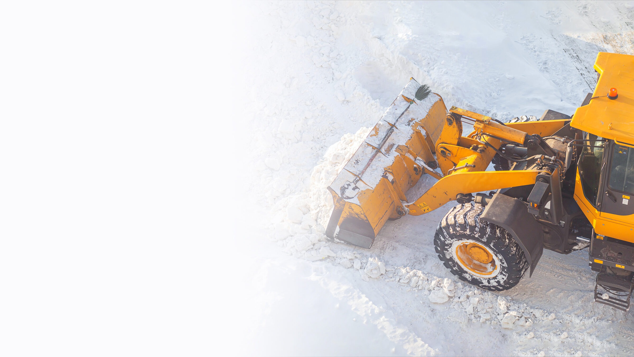 A yellow snowplow removes snow from a road, highlighting its capabilities in winter conditions. No people, landmarks, or buildings are visible.